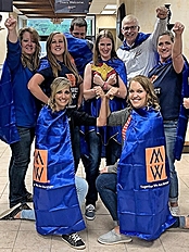 Minnwest team wearing capes and posing like super heros