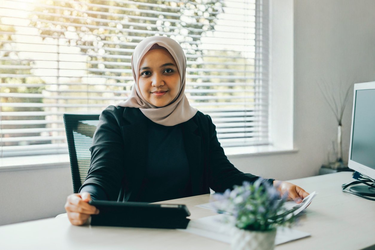 Woman wearing hijab sitting at an office desk