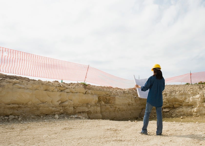 woman on work site looking at plans 