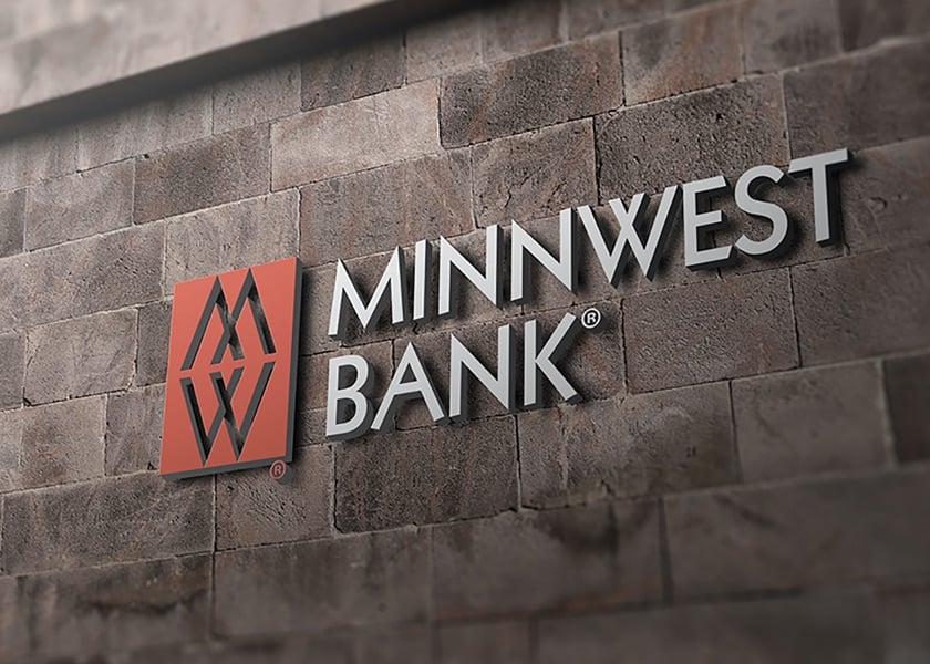 Minnwest bank logo on gray brick wall